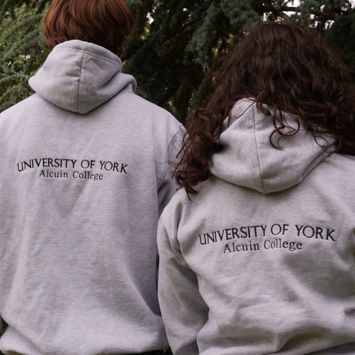Three people wearing gray hoodies with 'University of York' printed on the back, standing outdoors.