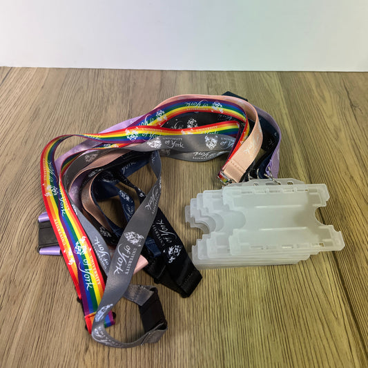 Lanyard with colorful design and a white plastic container on a wooden surface
