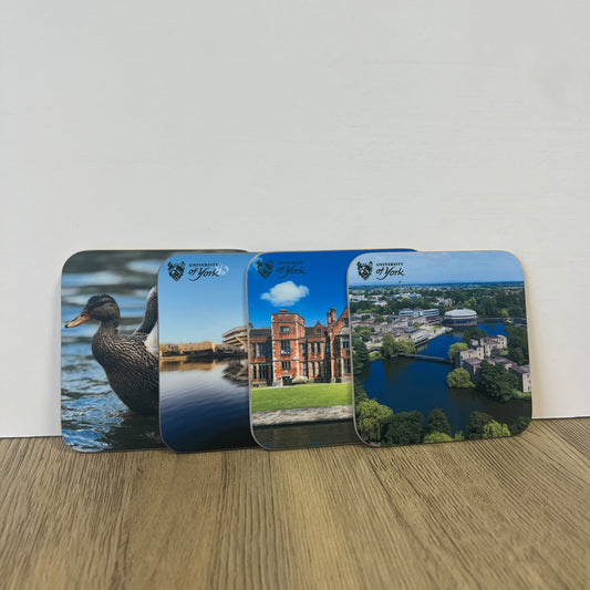 Two scenic postcards on a wooden surface with a white background
